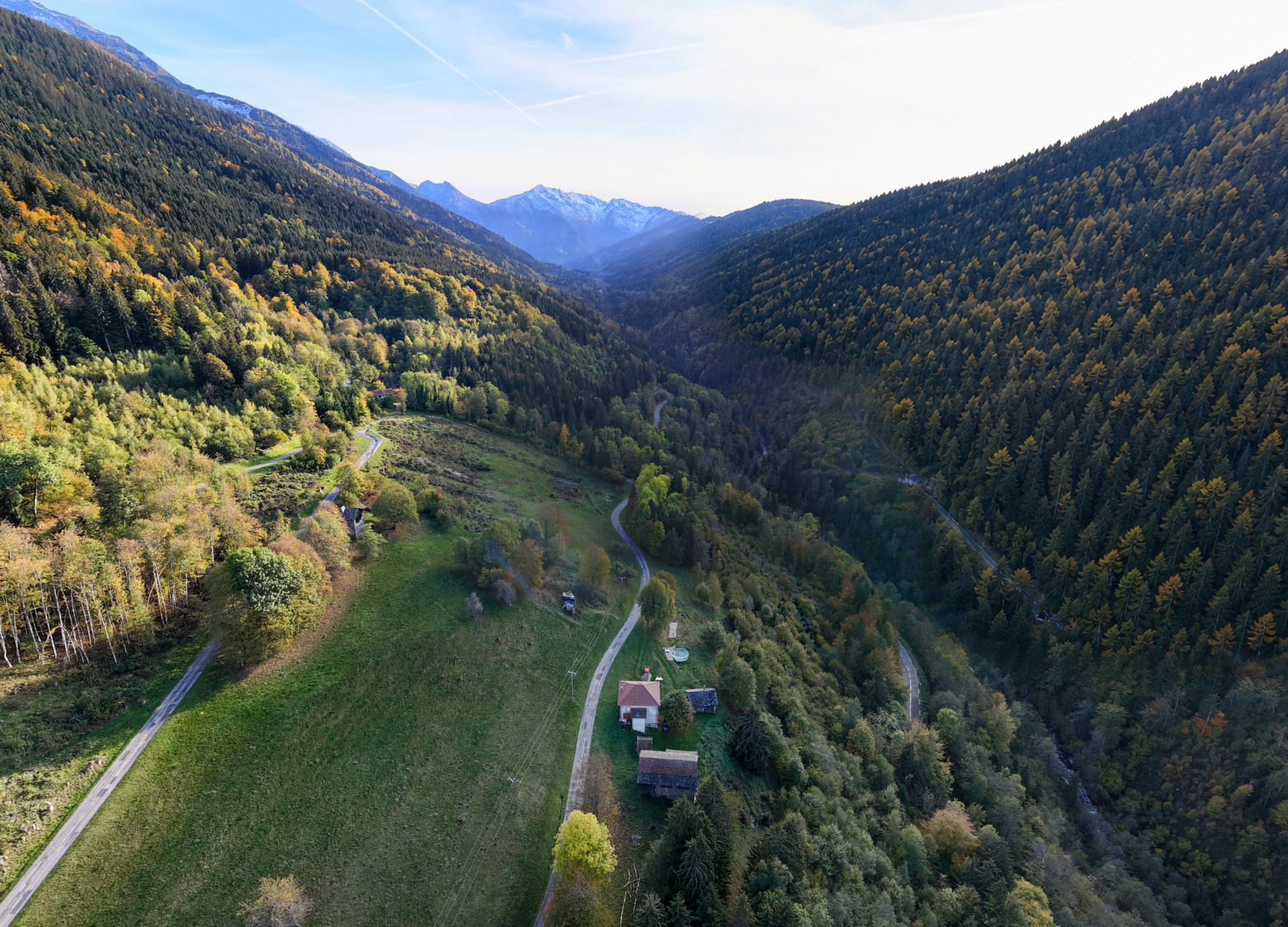 Vue sur la vallée depuis le Piat : prés, maisons, routes et sommets enneigés au loin